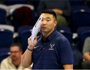 gallery-2 Coach whispering to team with paper in hand