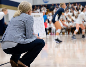 Coach watching game with paper in hand