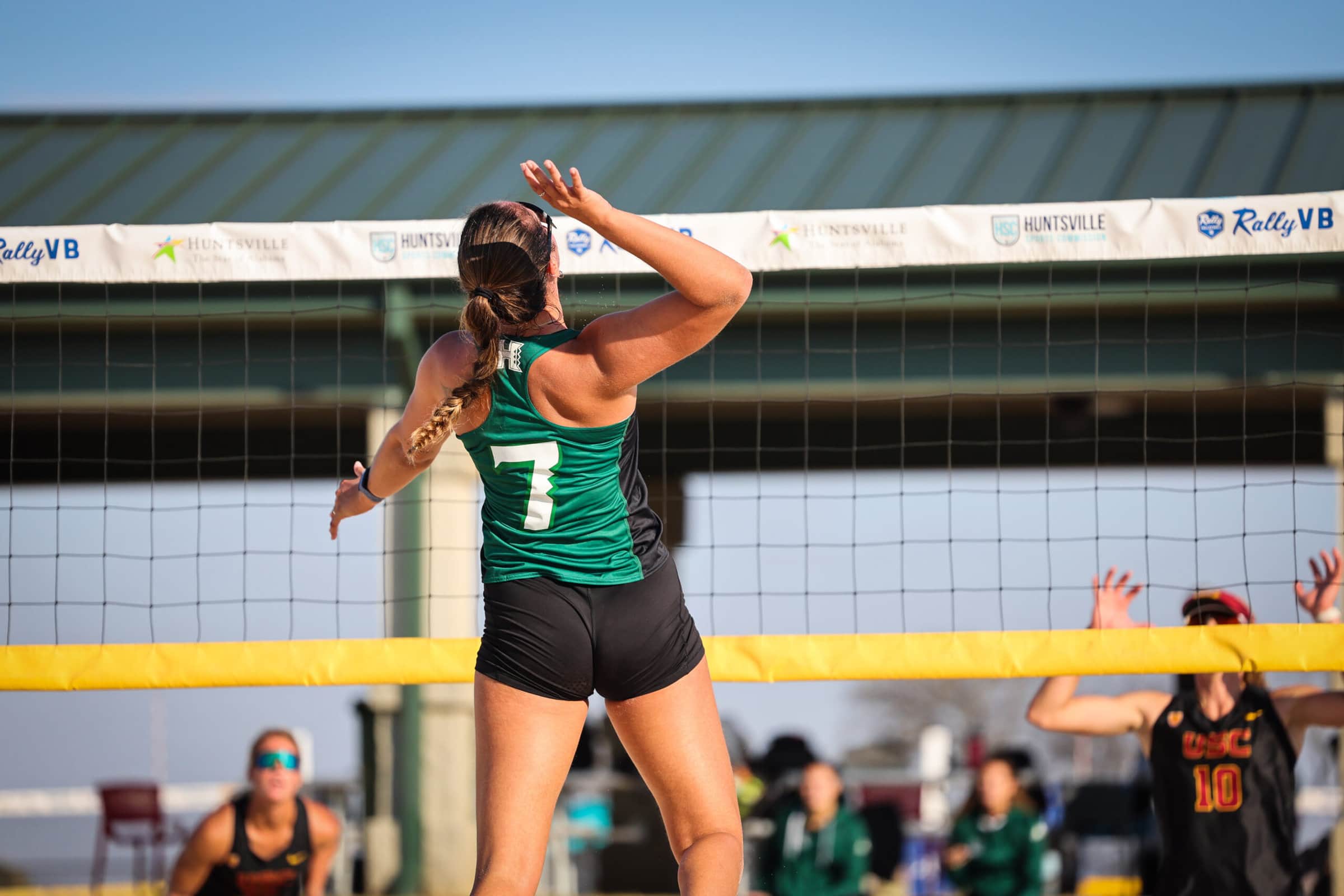 beach volleyball player hitting the ball over the net