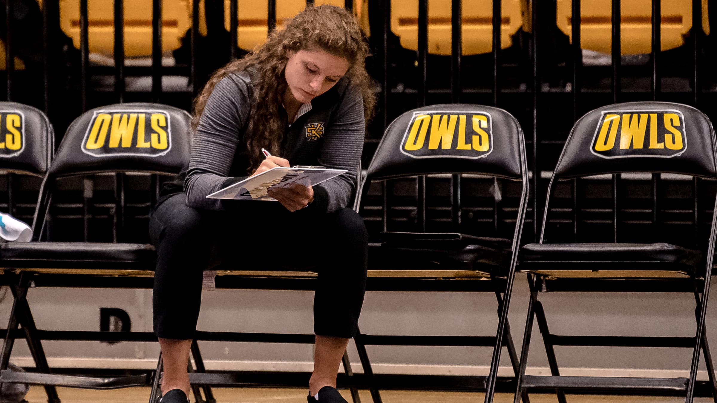Amie Held writing notes on the bench