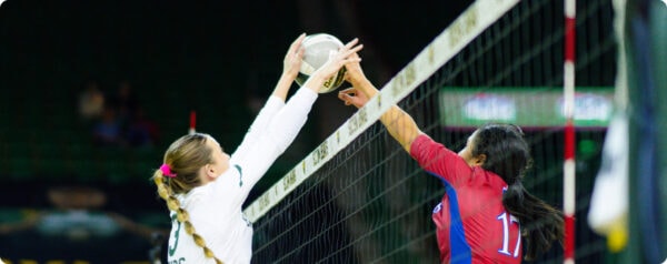 women's volleyball players at the net