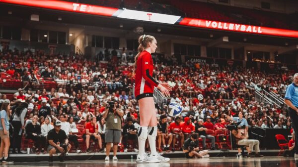 Texas Tech volleyball player getting ready to serve in front of a large crowd