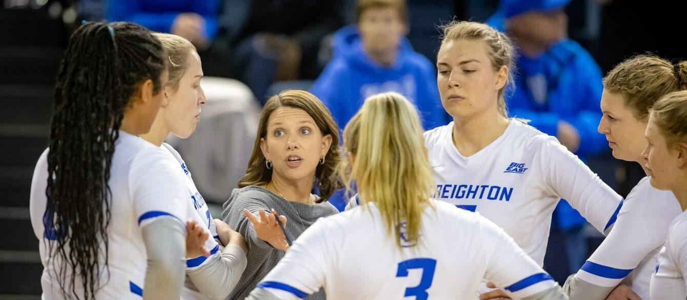 Kirsten Bernthal Booth talking with athletes in the huddle