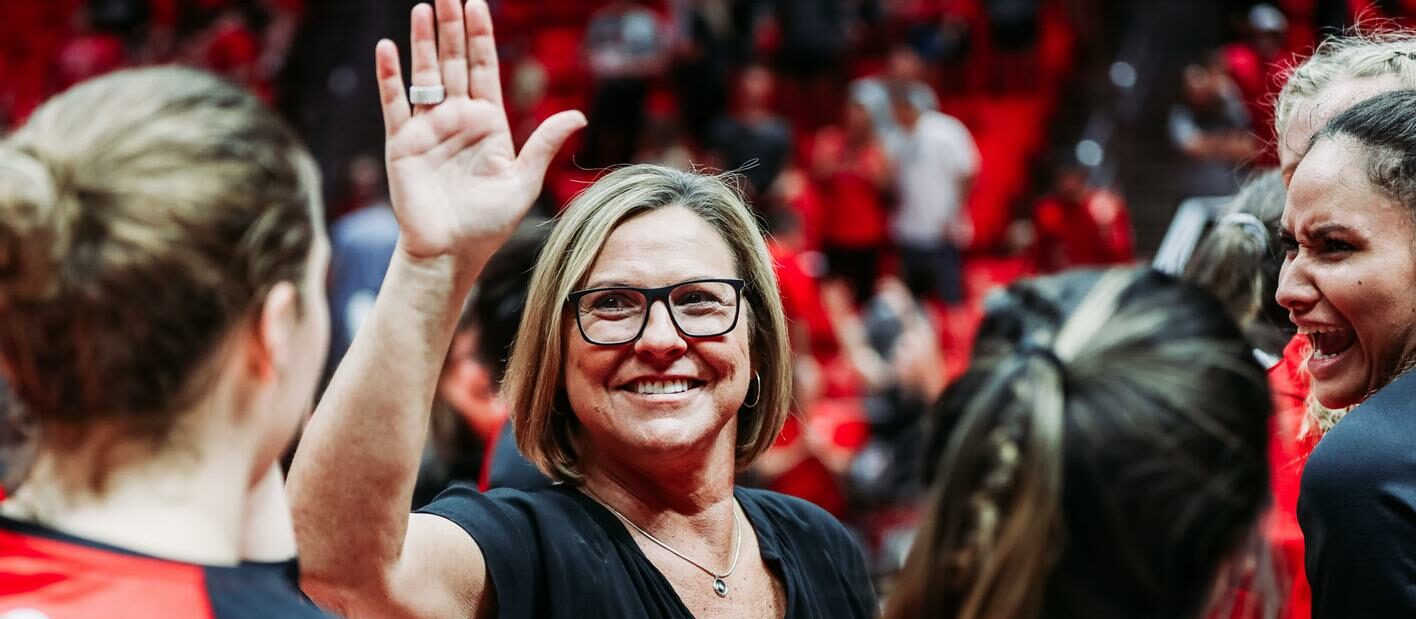 Beth Launiere with team high fiving athlete