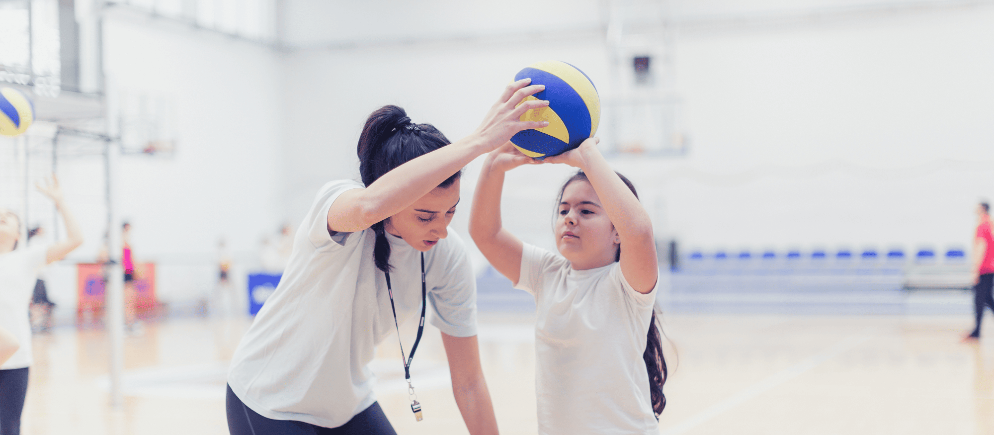 Volleyball coach working with beginning player