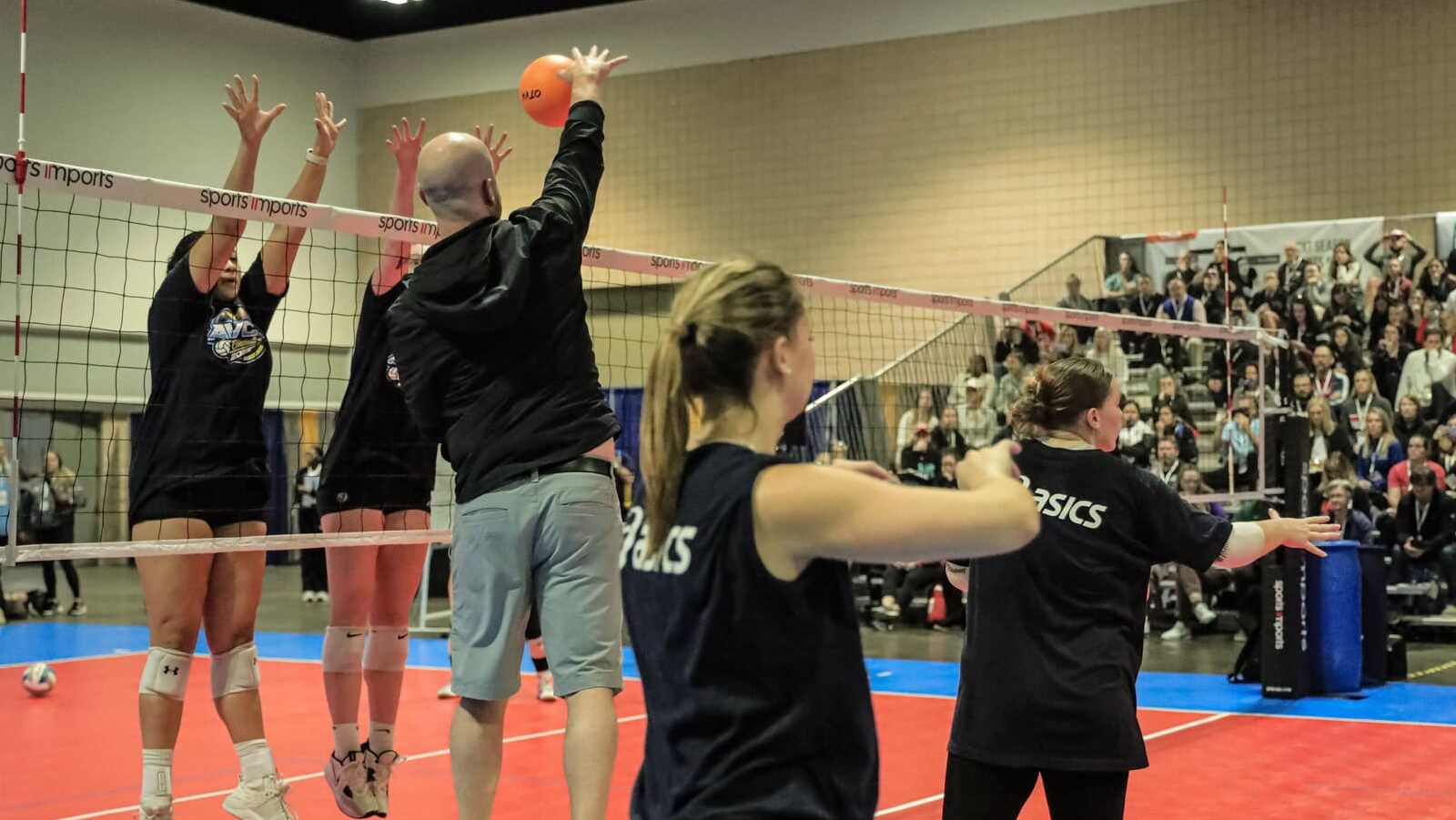 Coach on a box hitting at student athlete demonstrators at the AVCA Convention