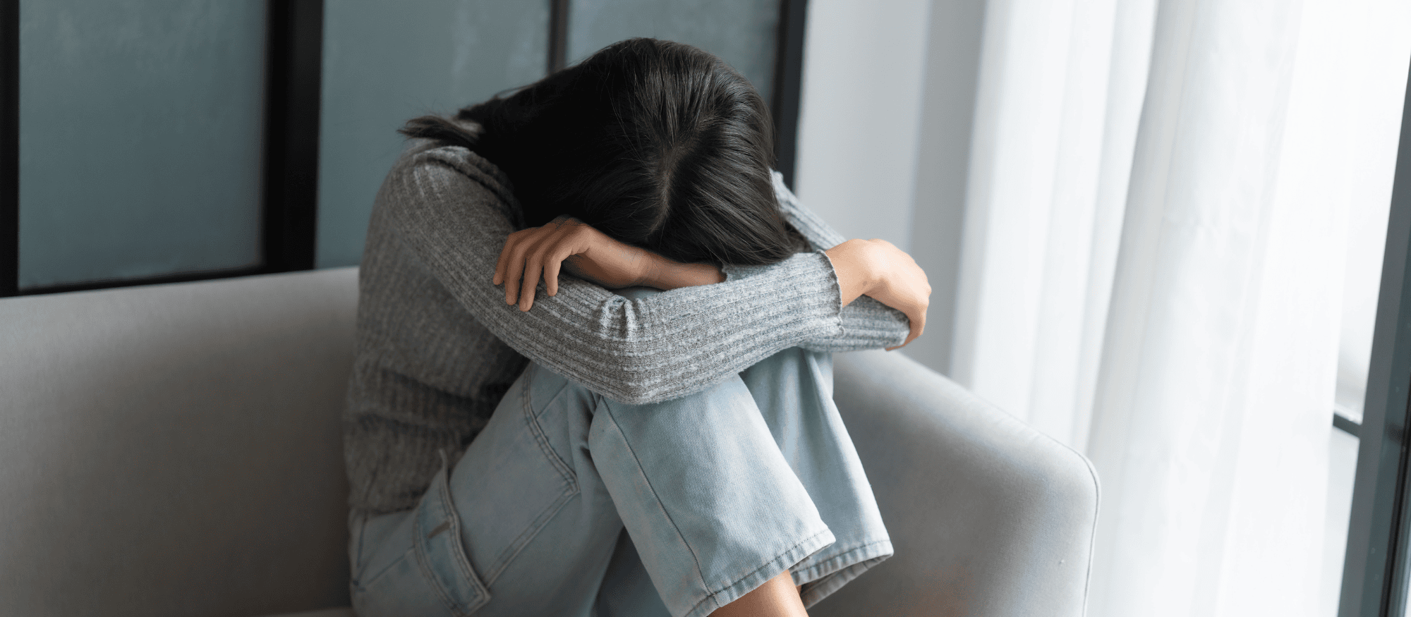 Person laying her head on her bend knees