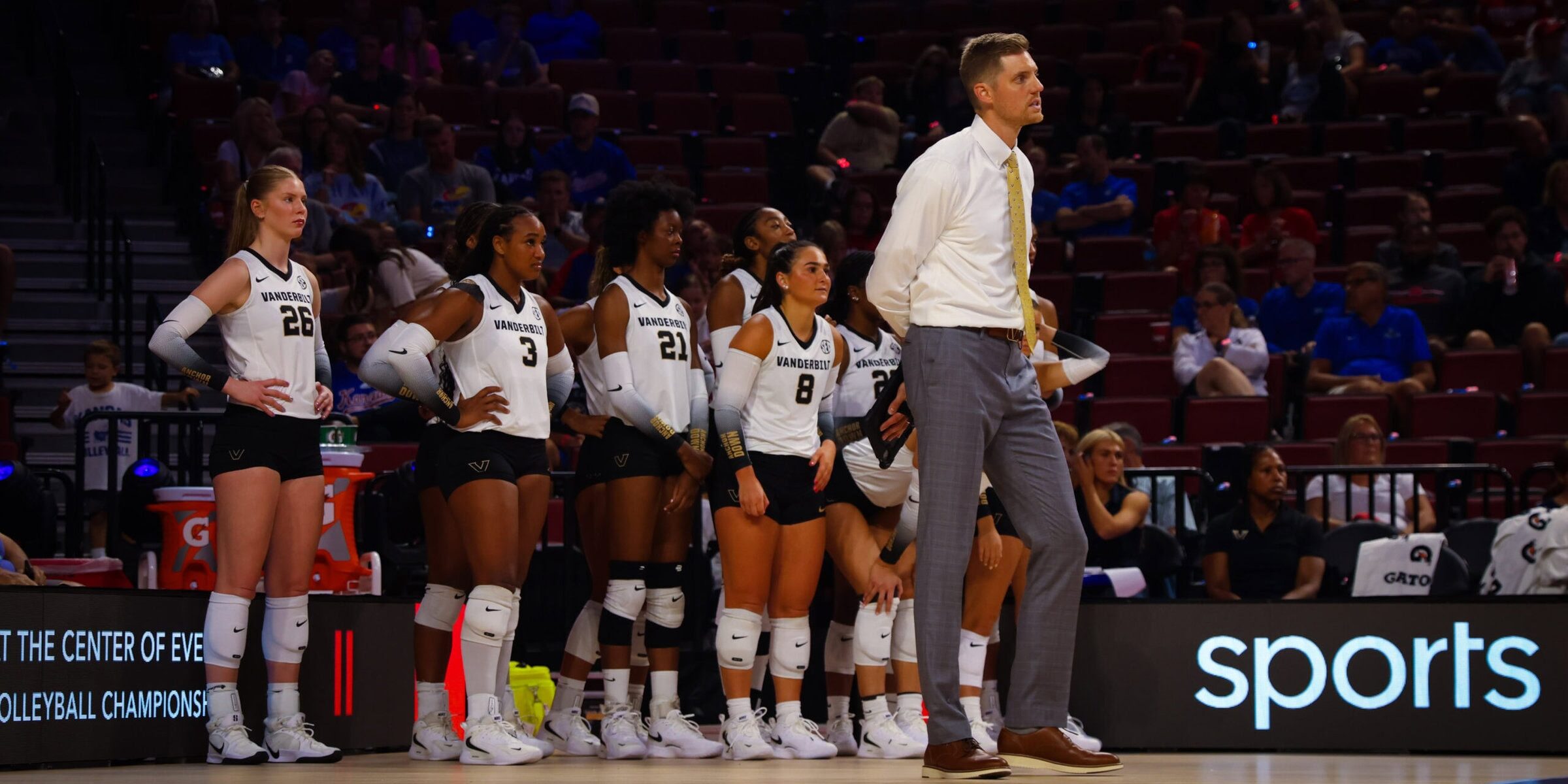 Anders Nelson standing in front of Vanderbilt volleyball team