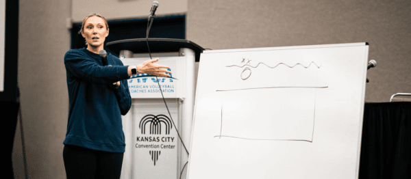 Volleyball coach presenting a classroom session in front of a white board