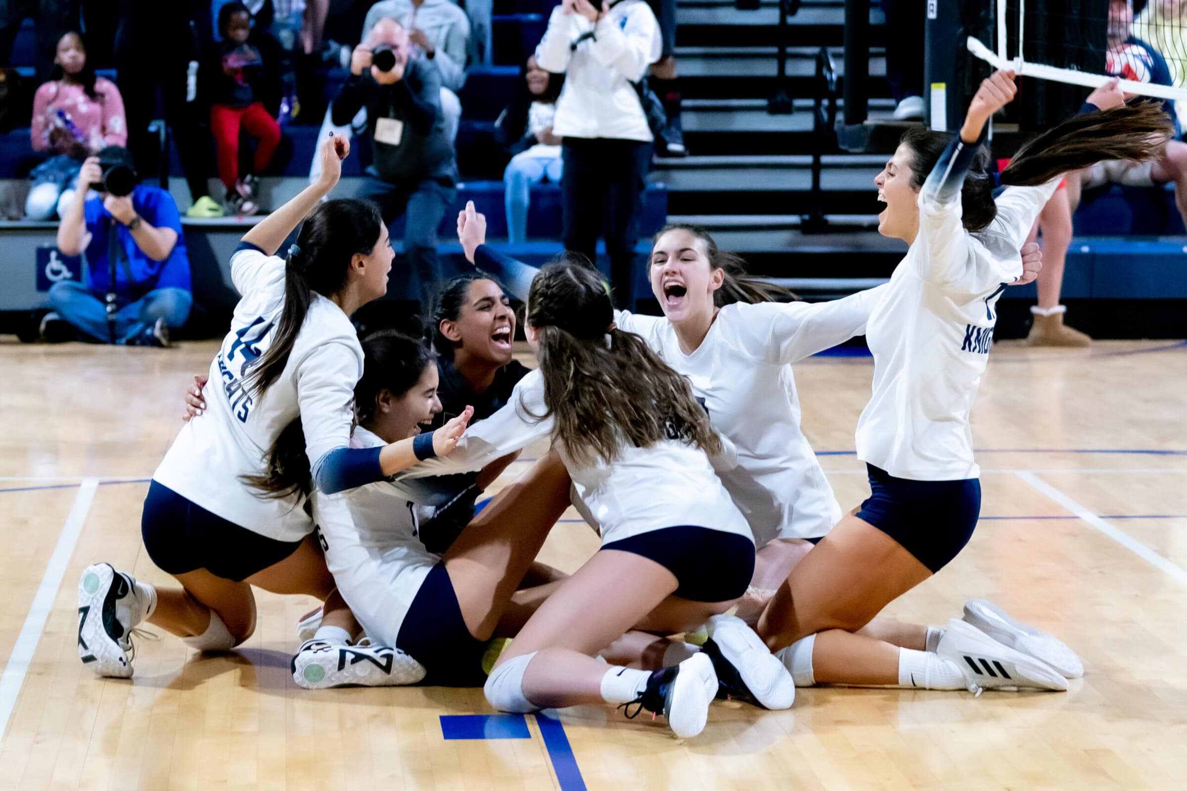 high school volleyball team celebrating