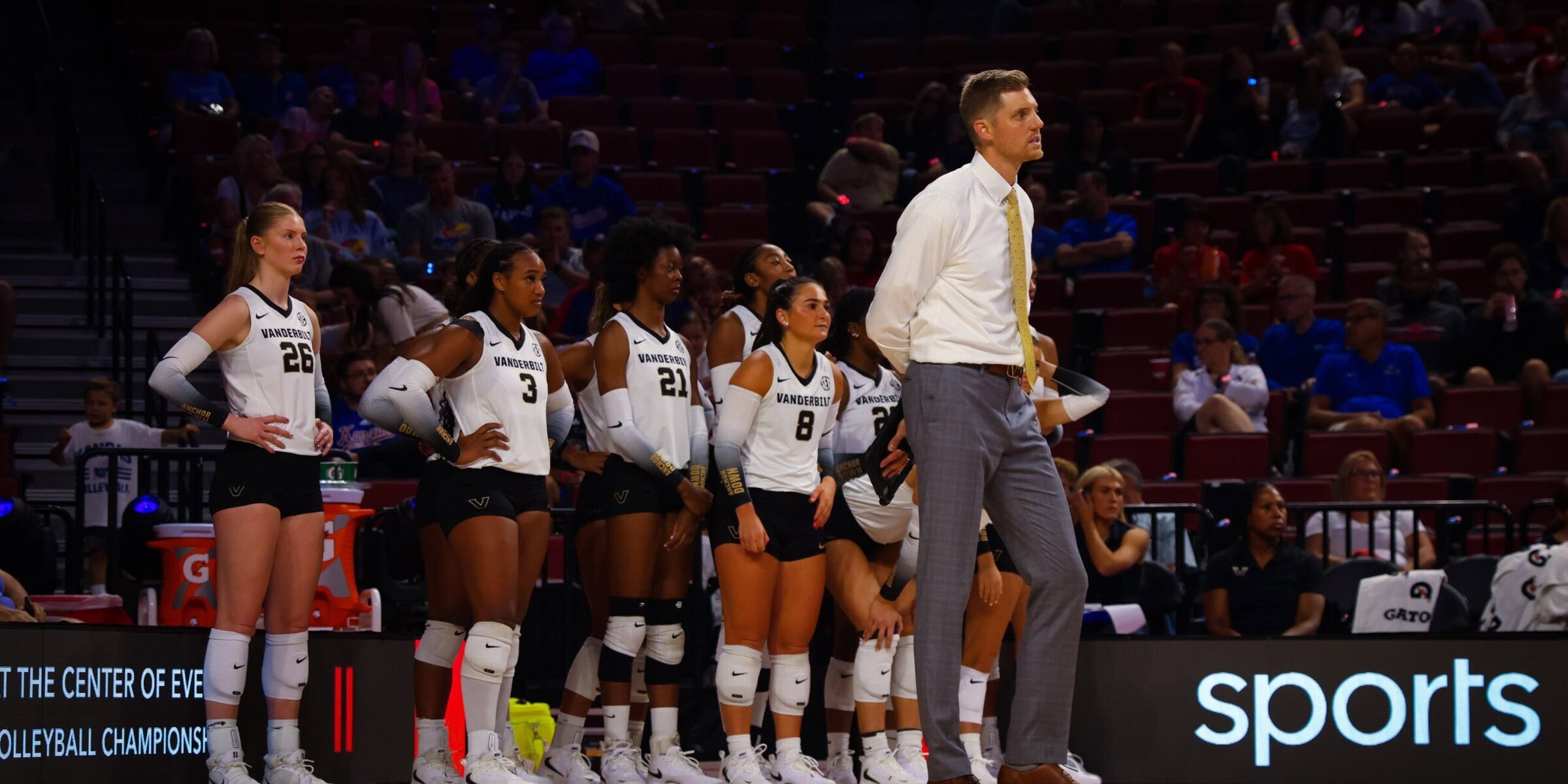 Anders Nelson standing in front of Vanderbilt volleyball team
