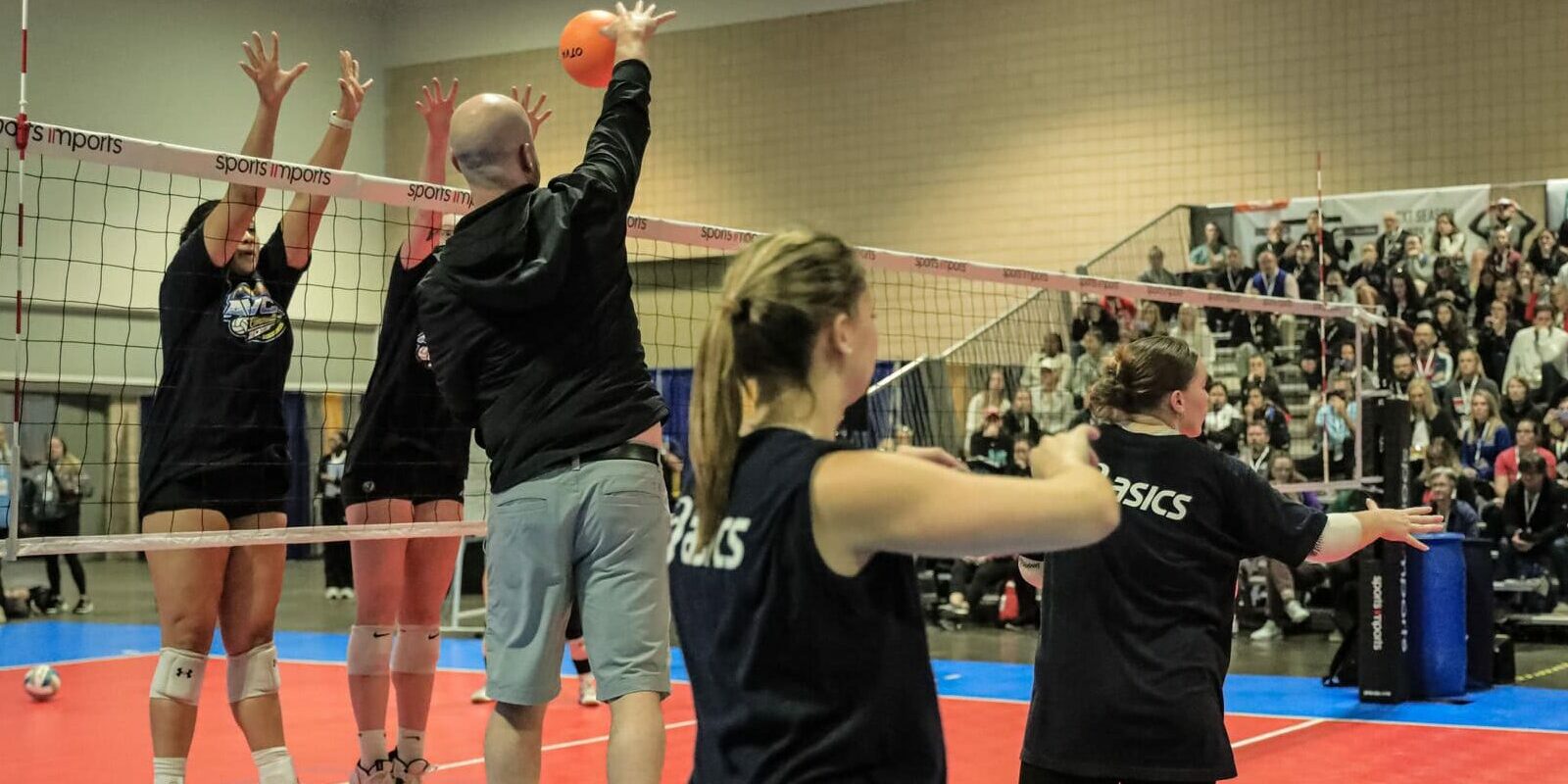 Coach on a box hitting at student athlete demonstrators at the AVCA Convention