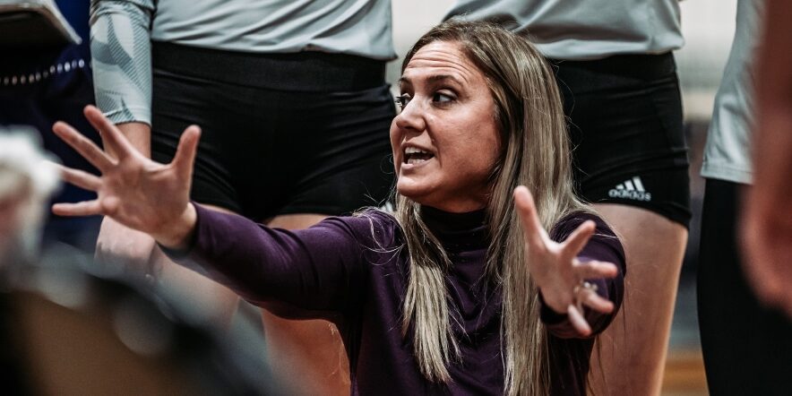 Volleyball coach instructs her team